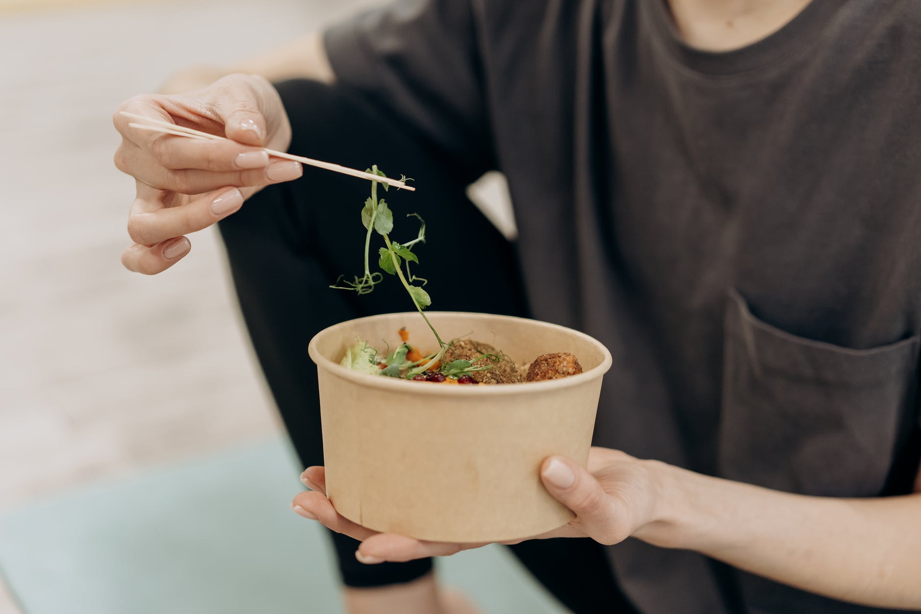 person holding a bowl with vegetables