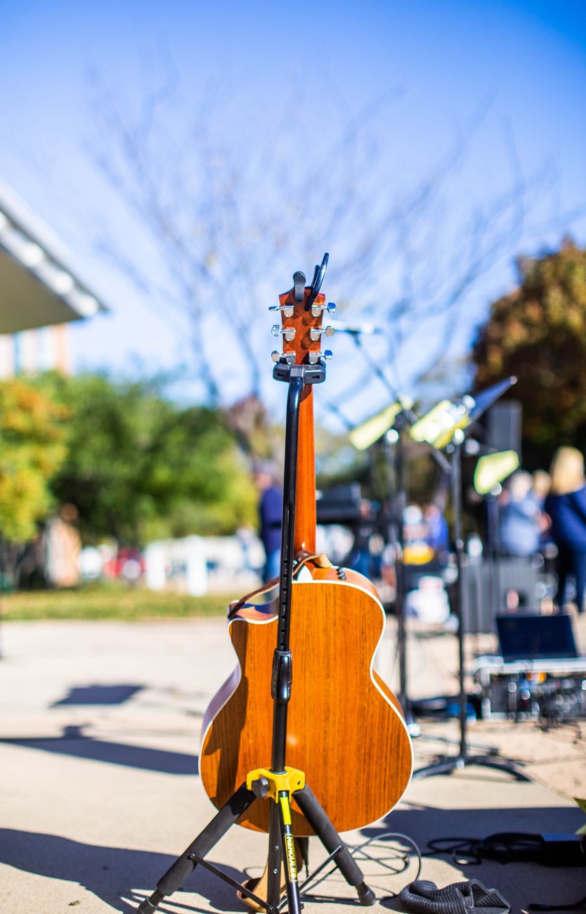 acoustic guitar on outdoor stage in sunny park