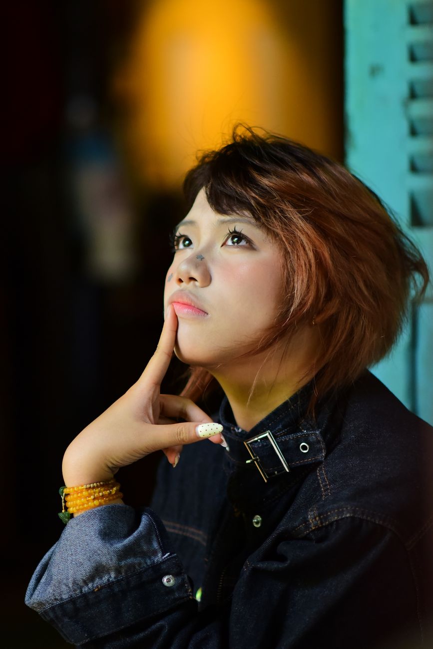 thoughtful young woman in moody lighting