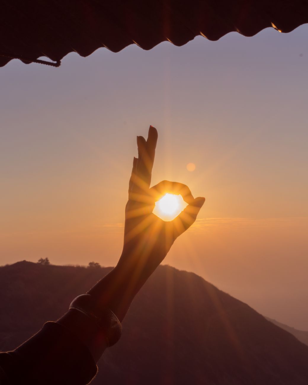 photography of hand during sunset
